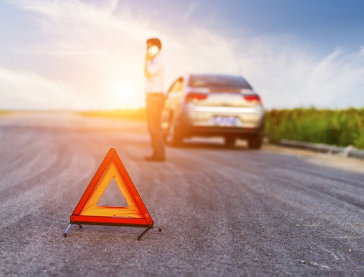 auto in panne con triangolo in primo piano