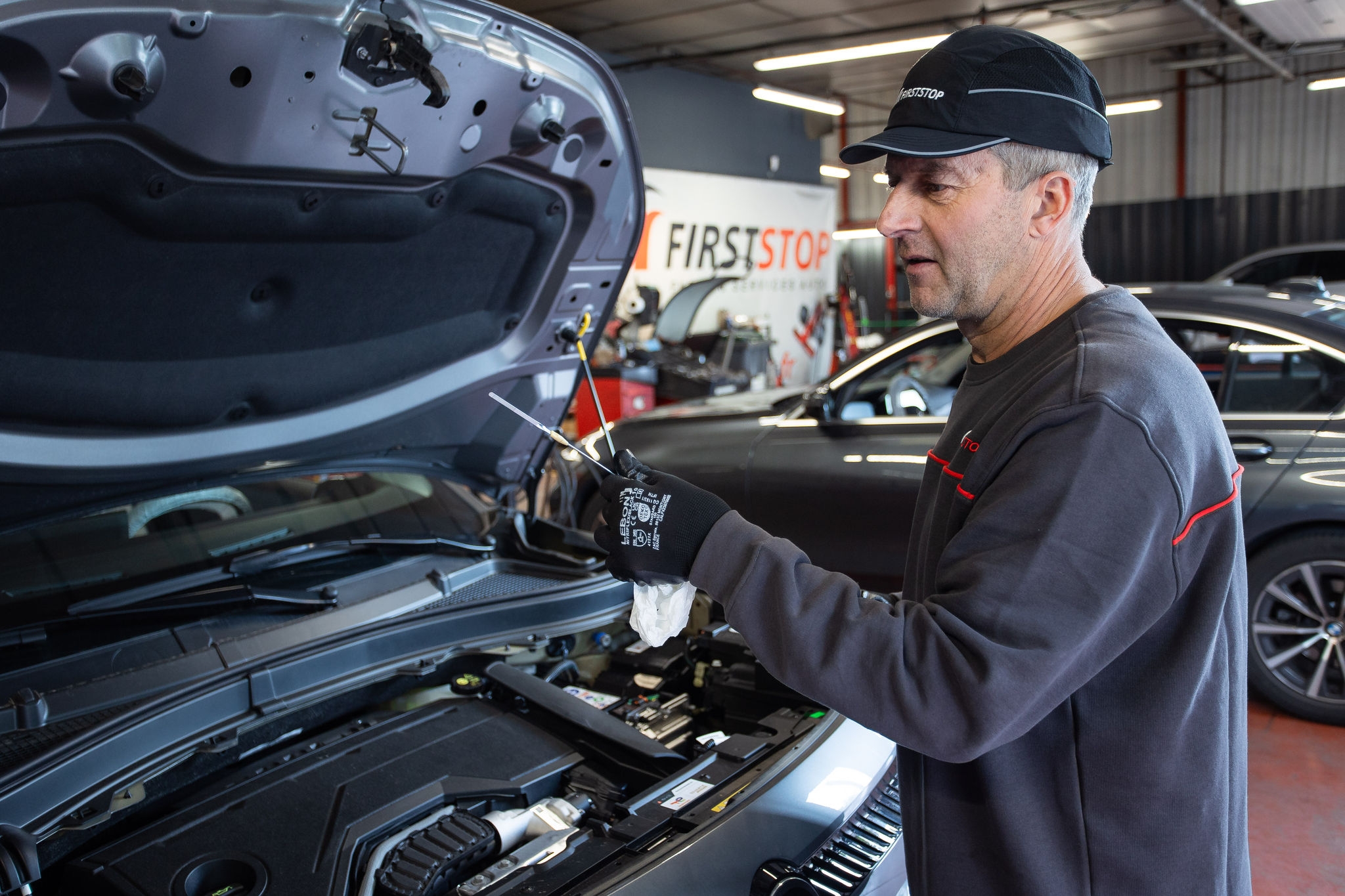 Meccanico controlla olio motore auto in officina