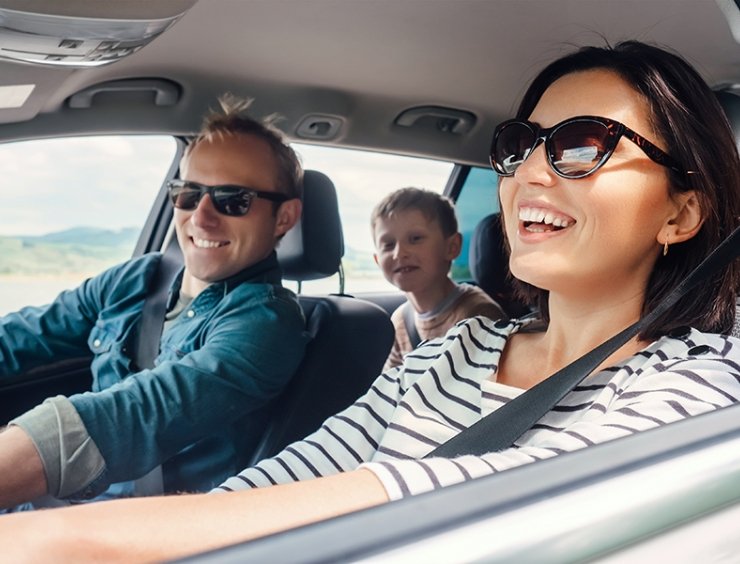 mamma alla guida con famiglia in auto