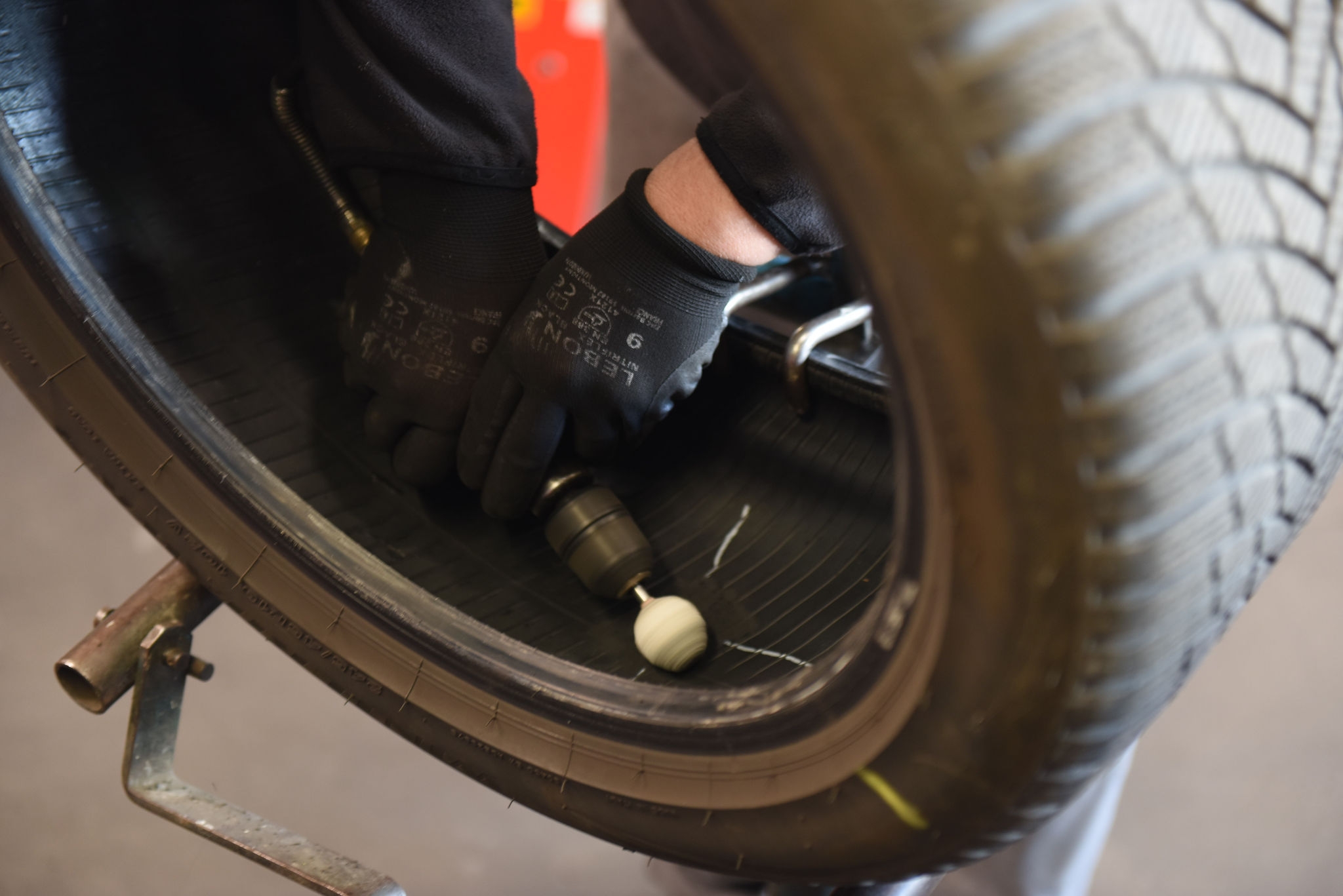 Riparazione pneumatico con strumento rotante in officina