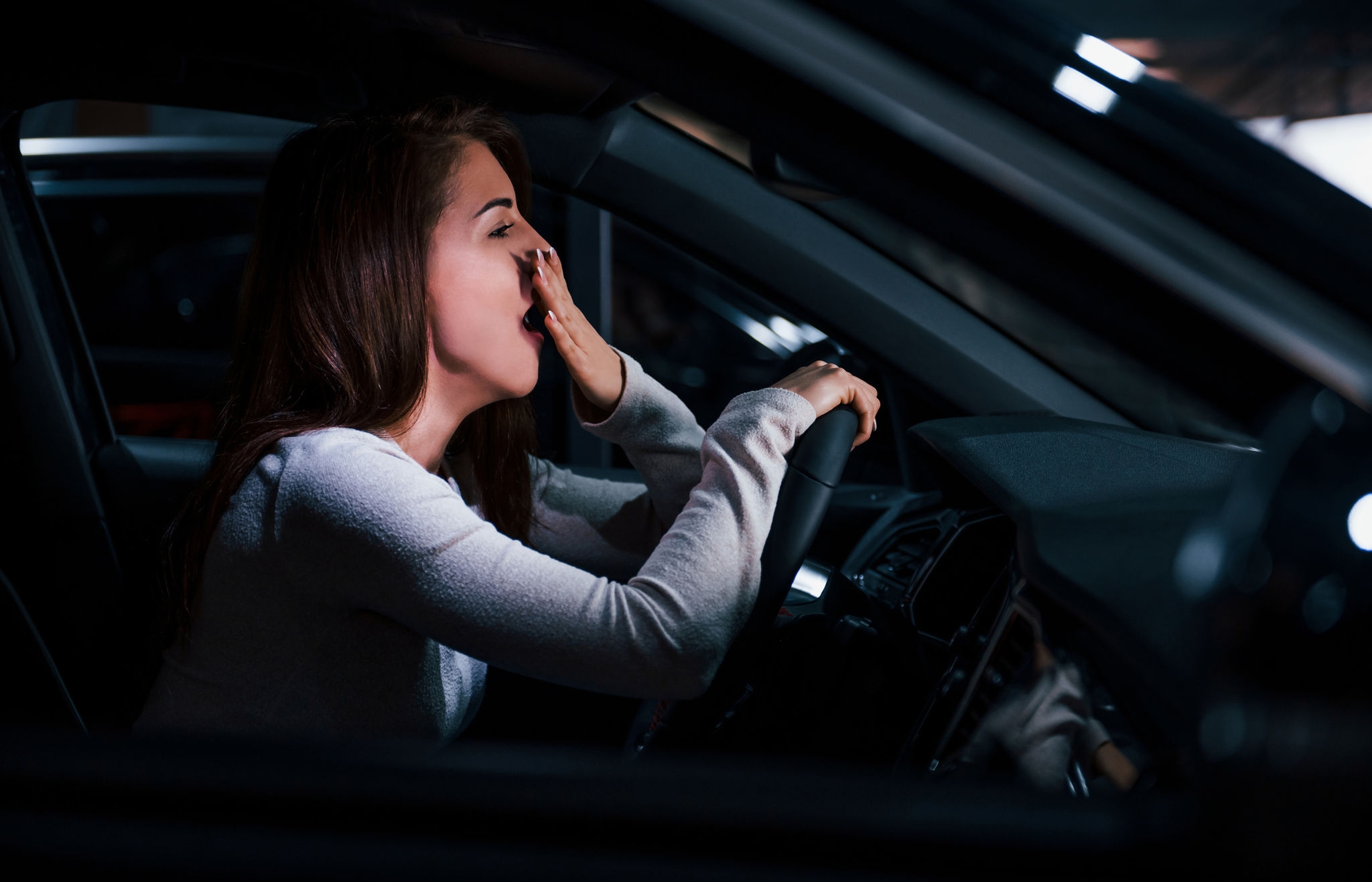 Side view of young woman that inside of brand new modern automobile Dormire in auto