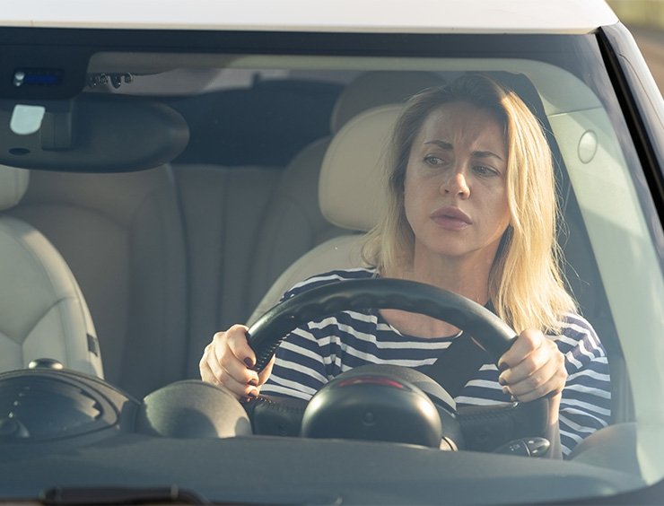 donna al volante ascolta rumore auto
