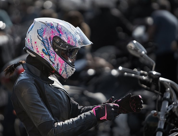 motociclista con casco si allaccia i guanti