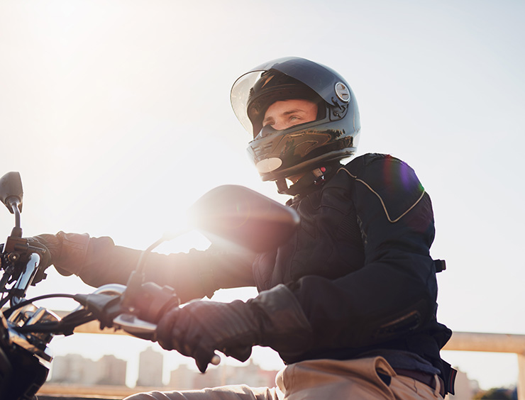 uomo con casco in sella a una moto